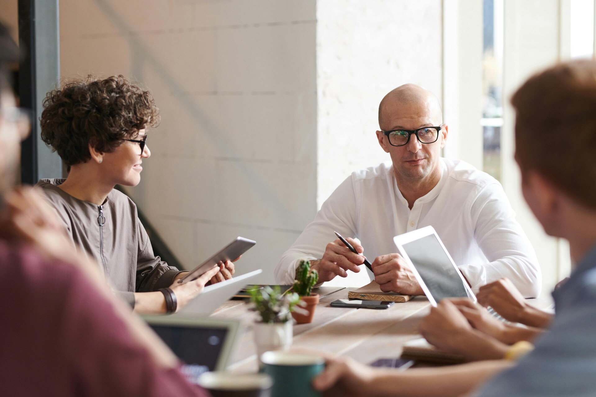 Meeting, Menschen an Tisch mit Laptops, Notizbüchern und Tablets